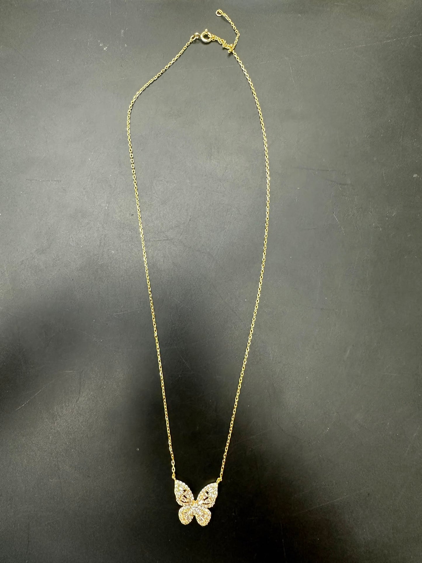 Sterling silver butterfly necklace NCZ1020 with gold plated finish and sparkling details on a dark background.