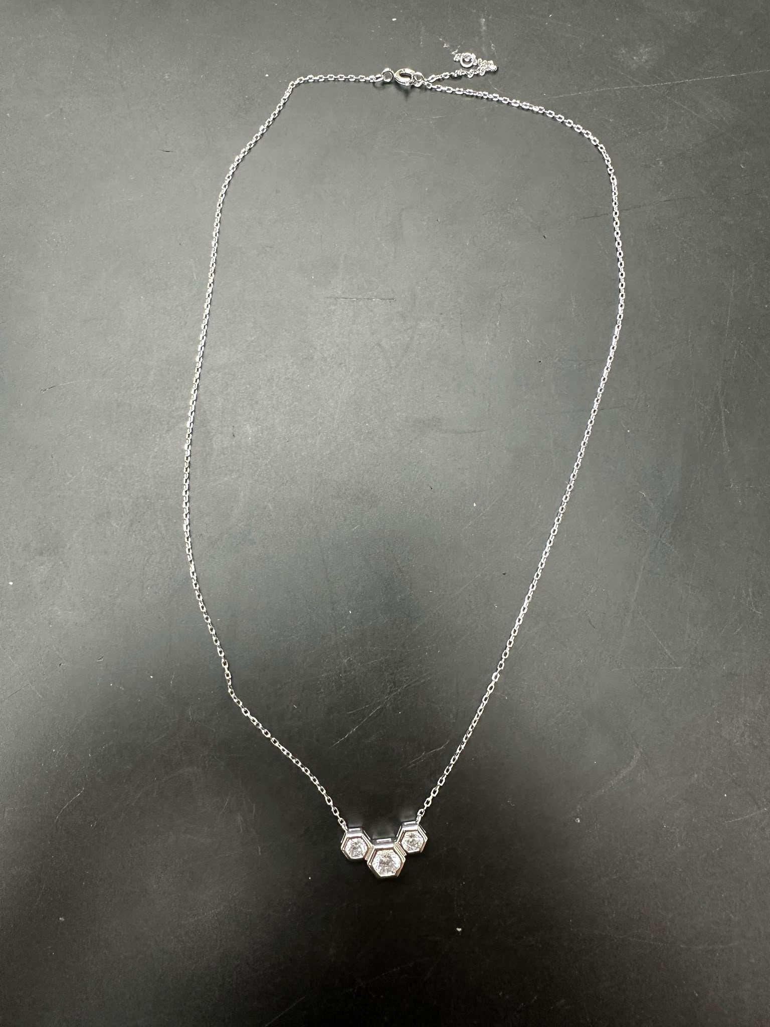 Sterling silver cz stone necklace featuring a unique design with three sparkling stones, 4.0mm and 5.0mm details.