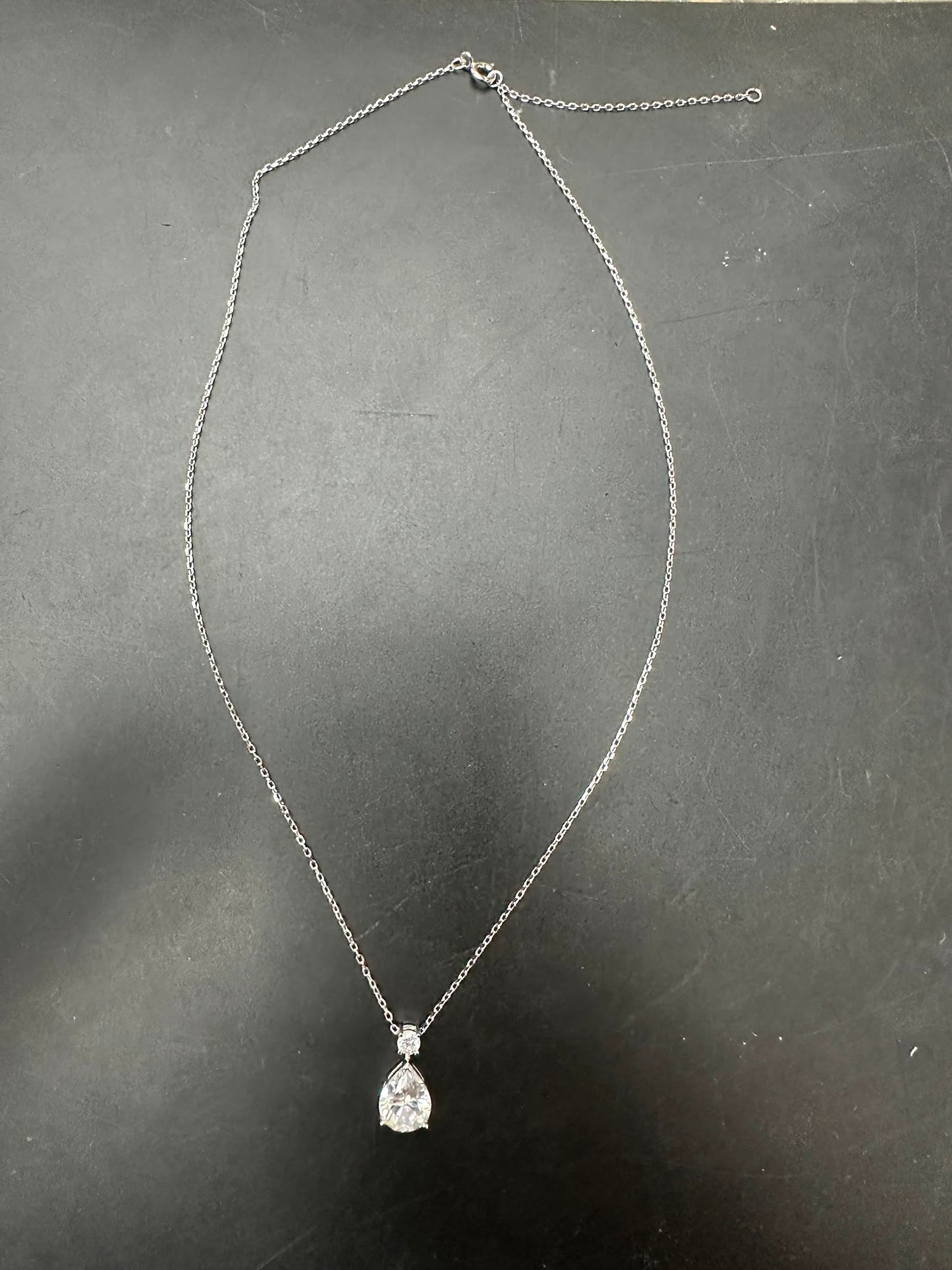 pear cut sterling silver necklace with diamond pendant set on a delicate chain.
