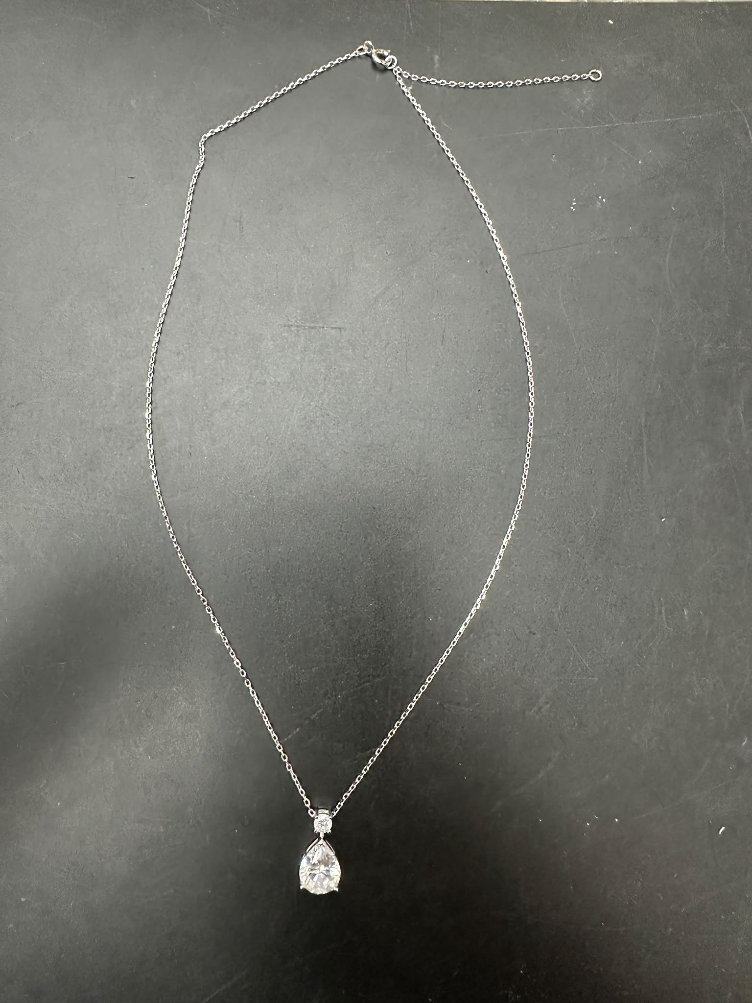 pear cut sterling silver necklace with diamond pendant set on a delicate chain.
