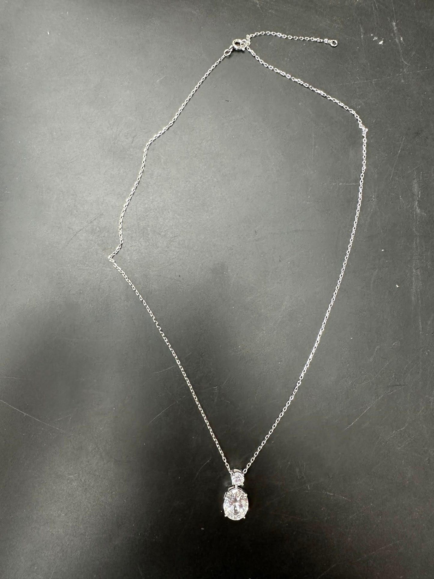 Sterling silver oval necklace featuring an 8*10mm oval stone and a 3.5mm round stone on a delicate chain.