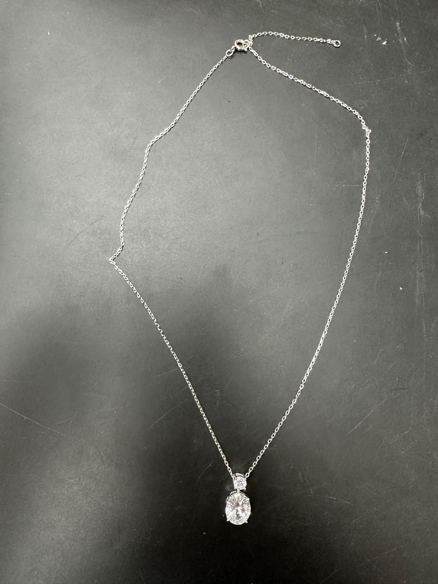 Sterling silver oval necklace featuring an 8*10mm oval stone and a 3.5mm round stone on a delicate chain.
