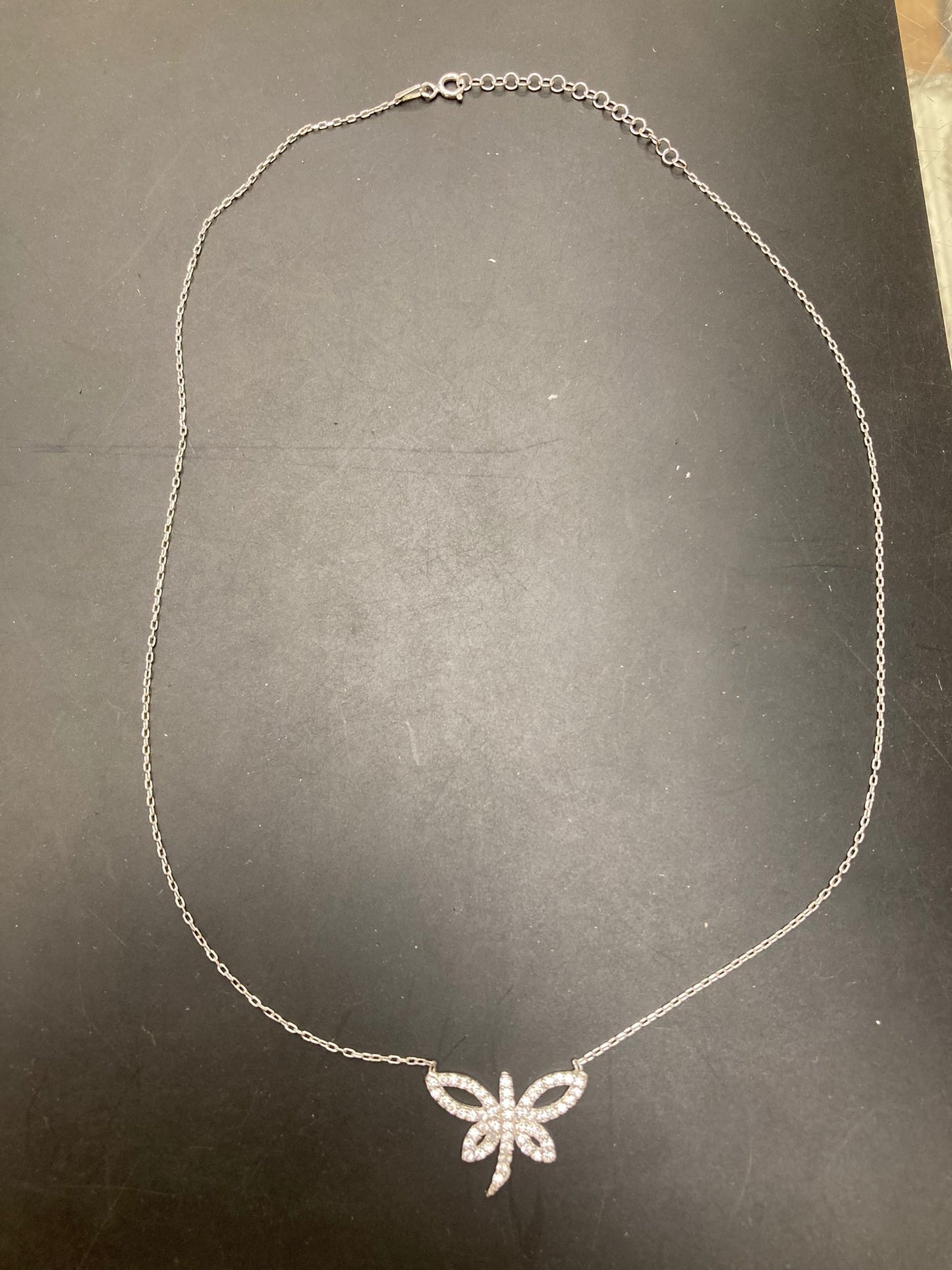 Sterling silver butterfly necklace NCZ9100 displayed on a black surface, showcasing intricate butterfly design.