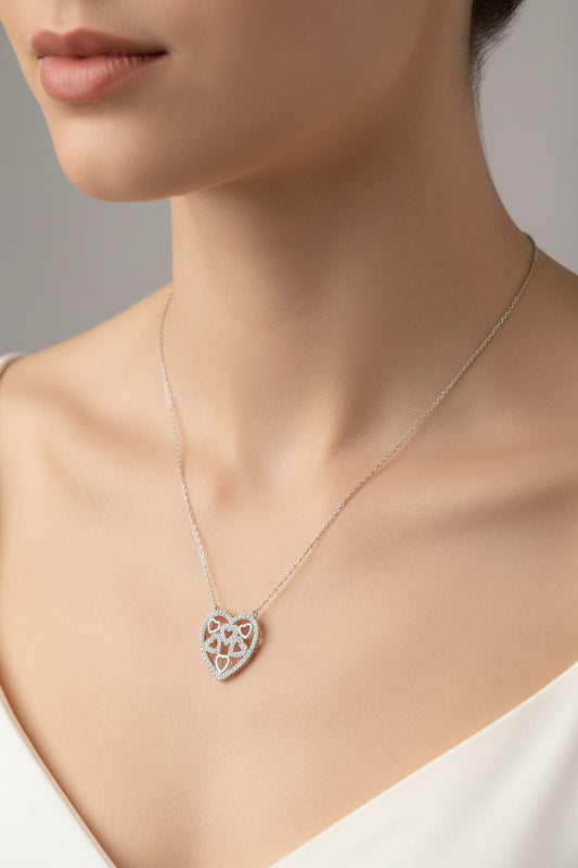 Sterling silver heart shaped necklace showcased on a woman's neck, featuring a heart design with cz stones.