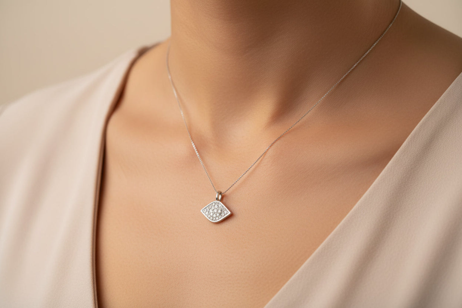 Close-up of a sterling silver cz evil eye pendant worn on a delicate chain around the neck.