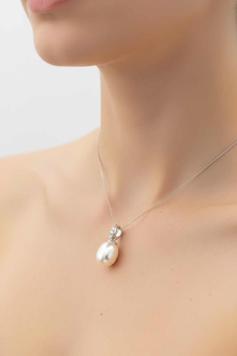 Close-up of a woman wearing a sterling silver pearl pendant on a delicate chain.