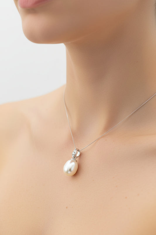 Close-up of a woman wearing a sterling silver pearl pendant on a delicate chain.