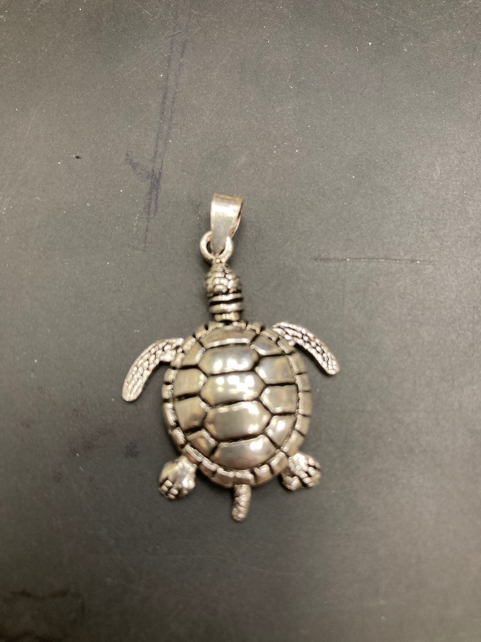 Sterling silver turtle pendant PN250870019 showcasing a detailed turtle design on a dark background.