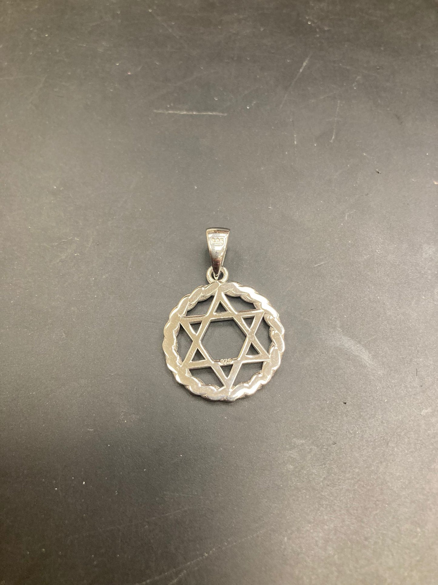 Sterling silver star of david pendant showcasing a delicate design and intricate details.