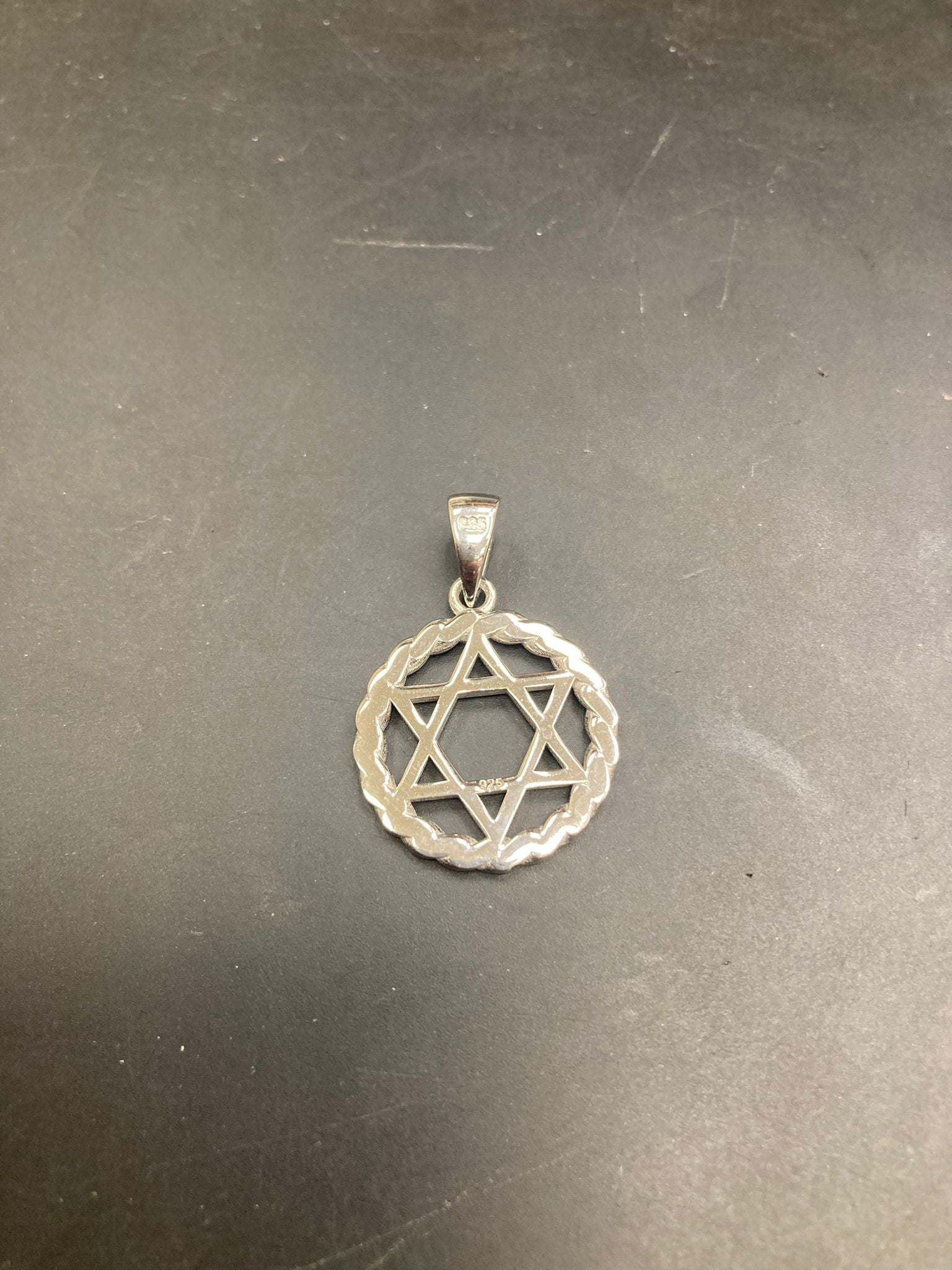 Sterling silver star of david pendant showcasing a delicate design and intricate details.