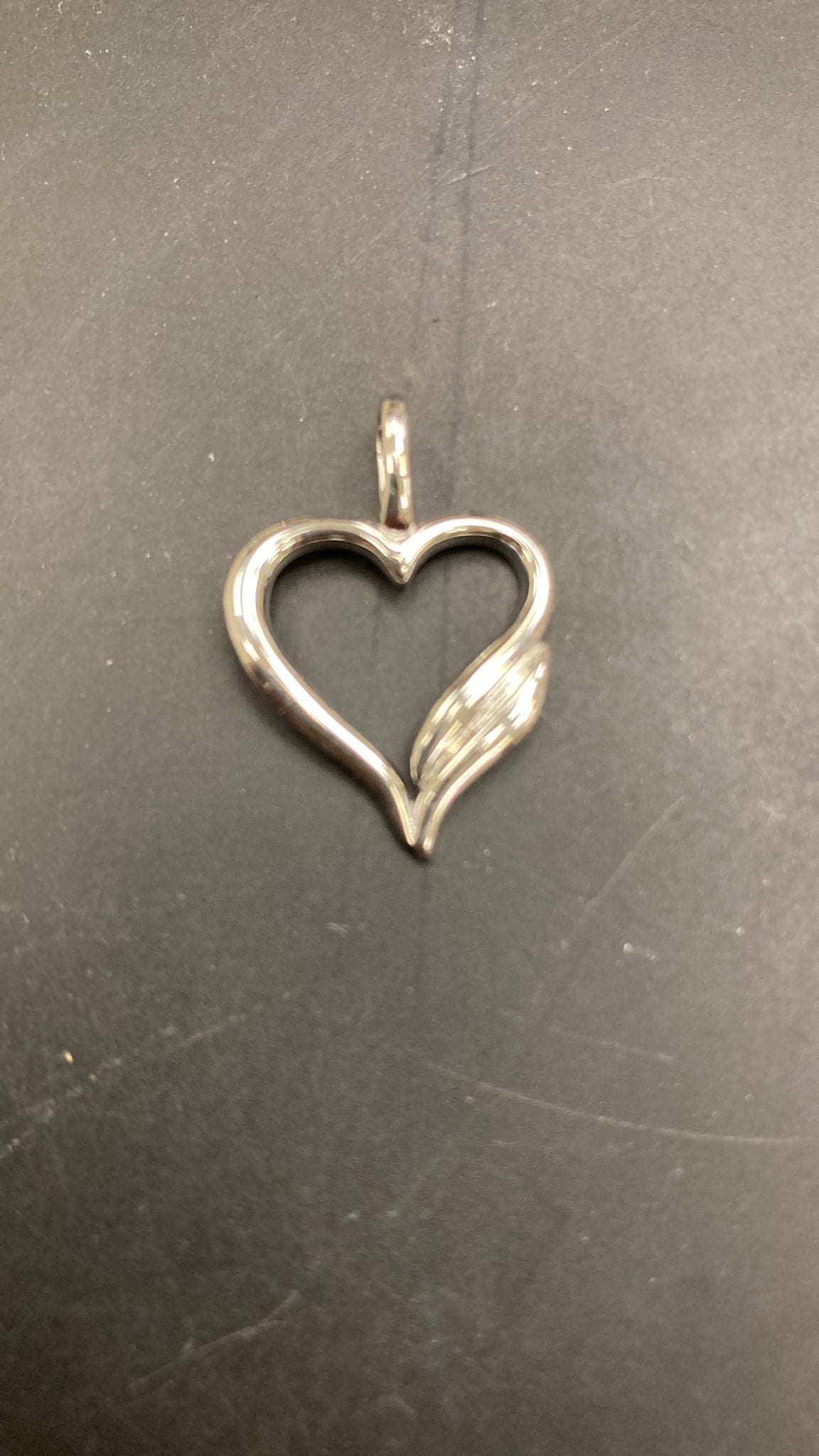 Sterling silver heart pendant featuring a plain open heart design with a decorative swirl.