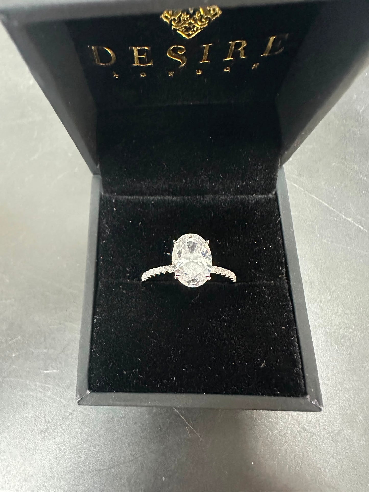 Sterling silver oval shape ring RCZ2475 displayed in black velvet box with oval center stone.