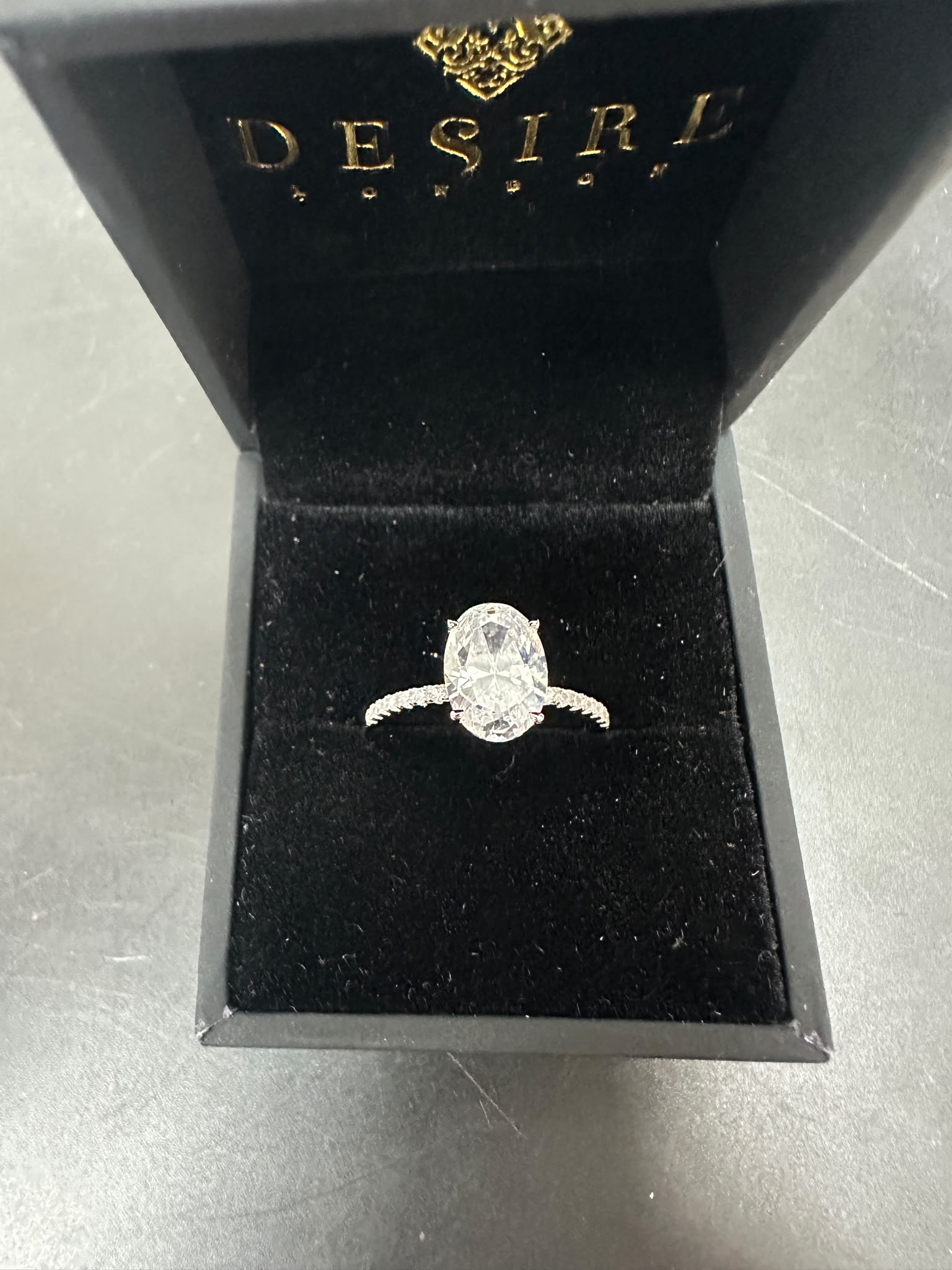 Sterling silver oval shape ring RCZ2475 displayed in black velvet box with oval center stone.