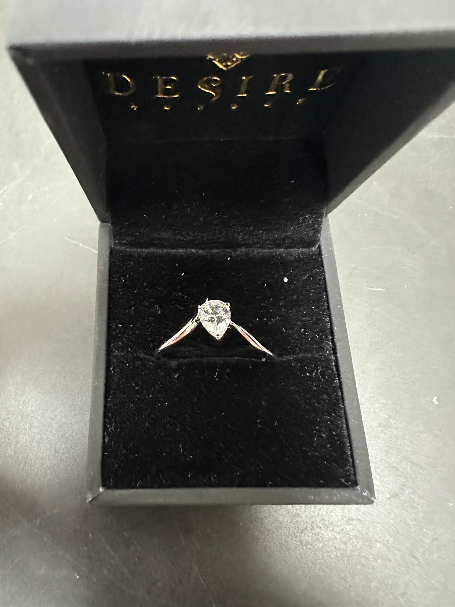 pear cut sterling silver ring with cz stone in a black jewelry box.