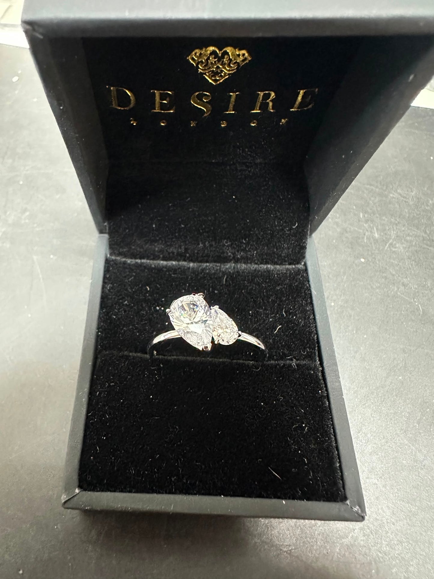 Sterling silver two pear stone ring featuring CZ stones in a desire jewelry box.