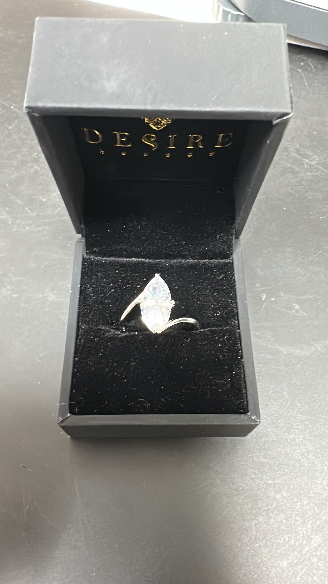 Sterling silver marquise ring with cz stone displayed in a black jewelry box with Desire branding.