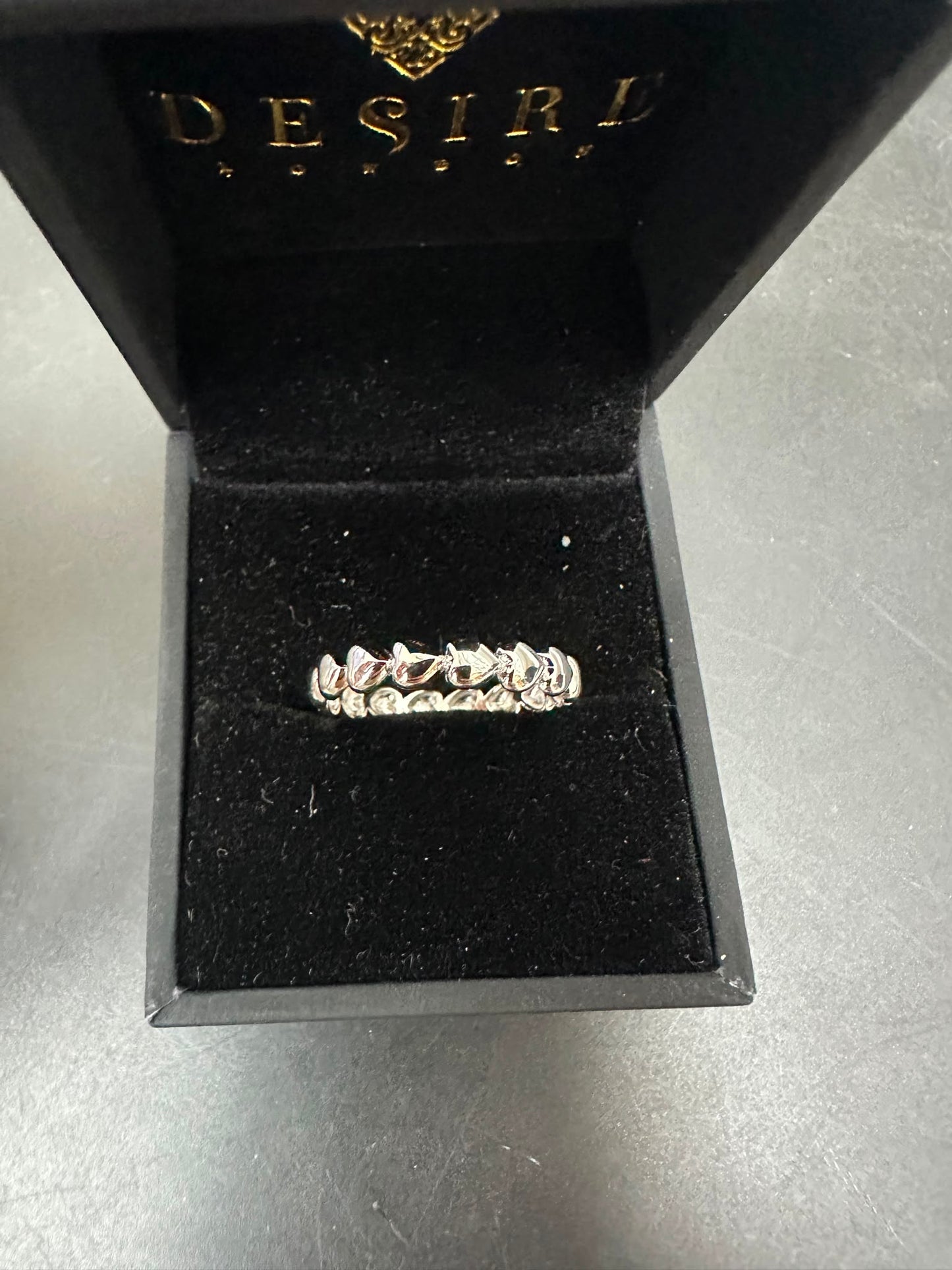Sterling silver eternity ring displayed in a luxury Desire jewelry box with a black velvet interior.
