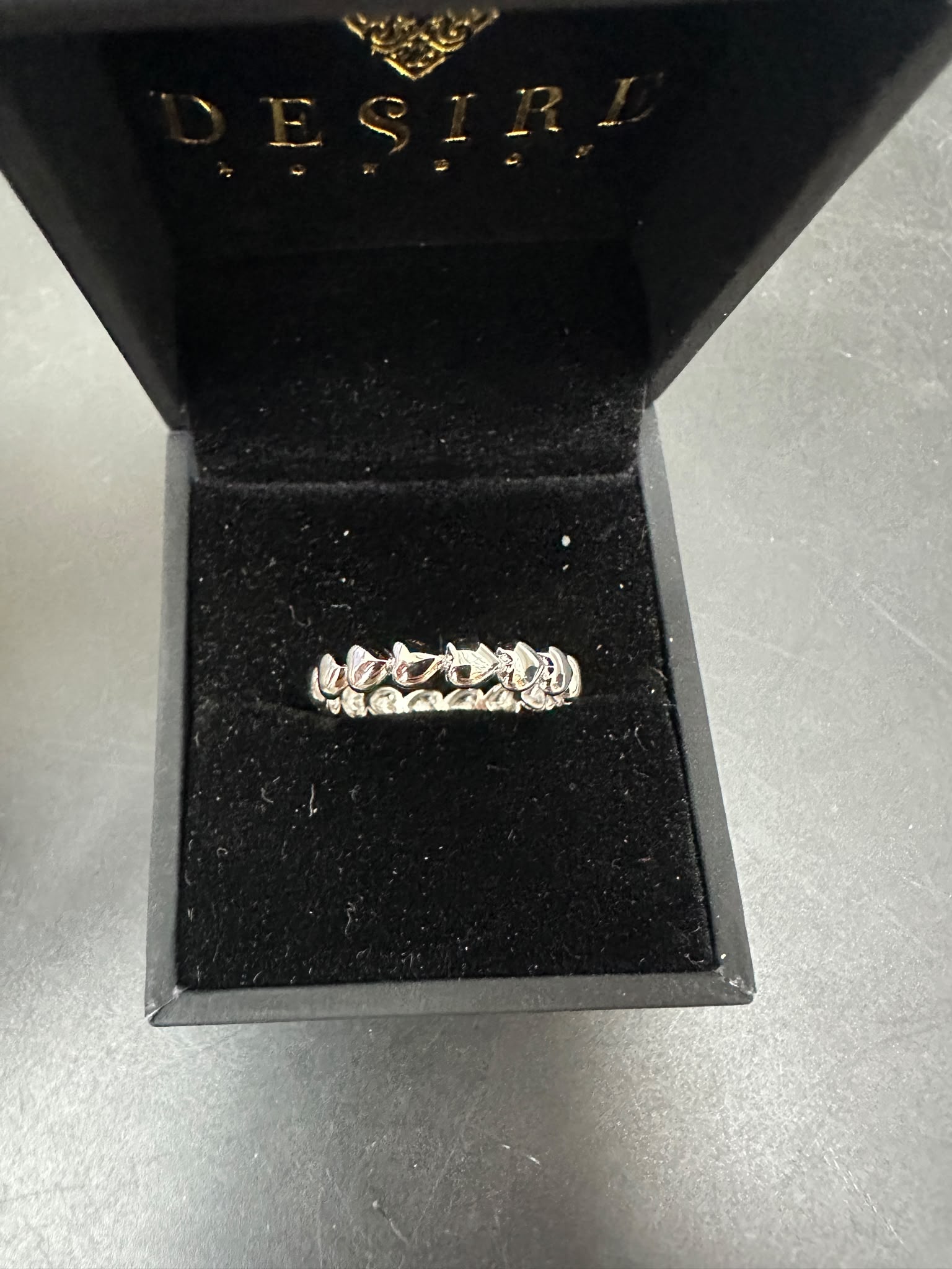 Sterling silver eternity ring displayed in a luxury Desire jewelry box with a black velvet interior.