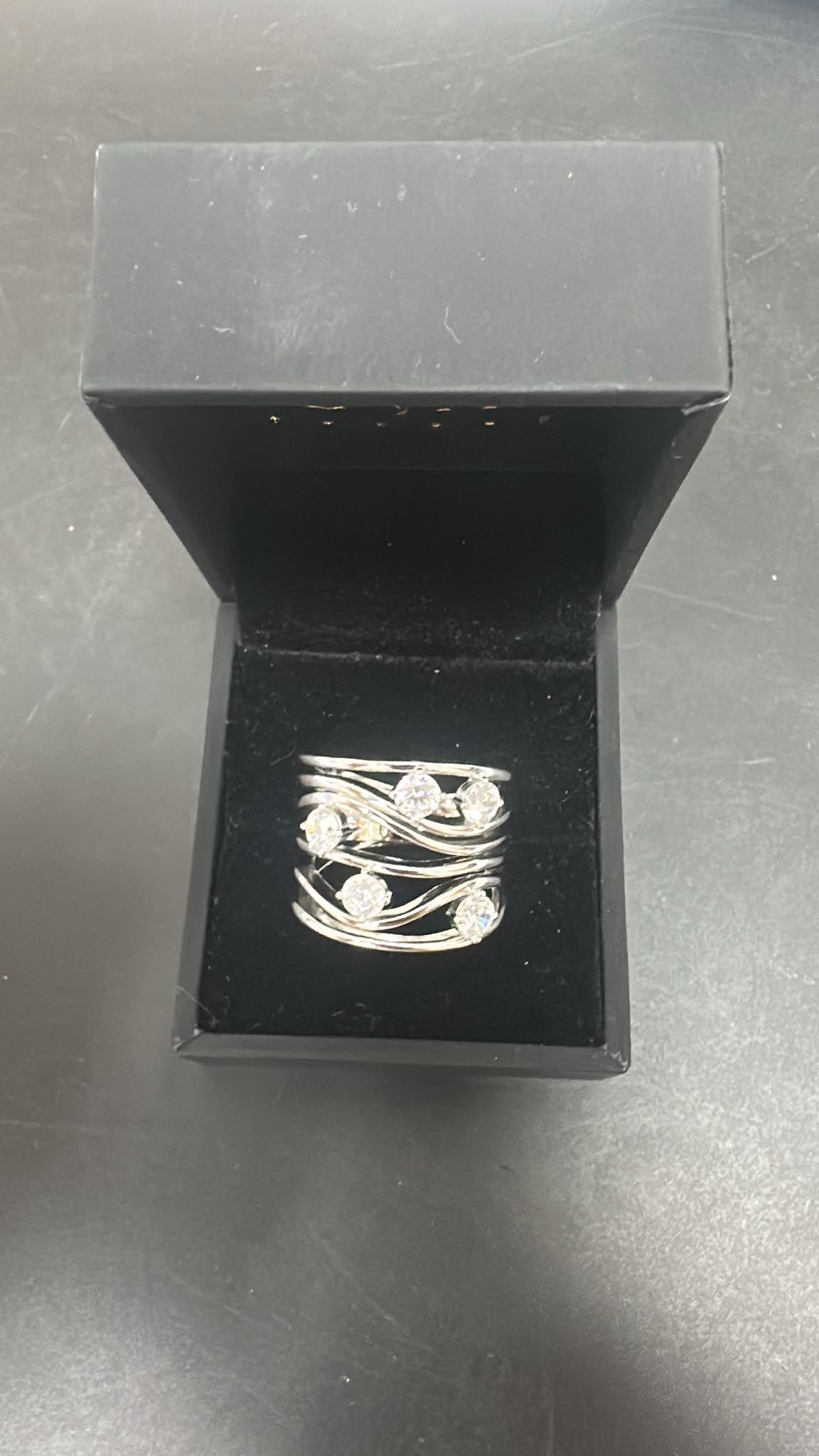 sterling silver round cz ring displayed in a black box, featuring multiple sparkling cz stones, elegant design.