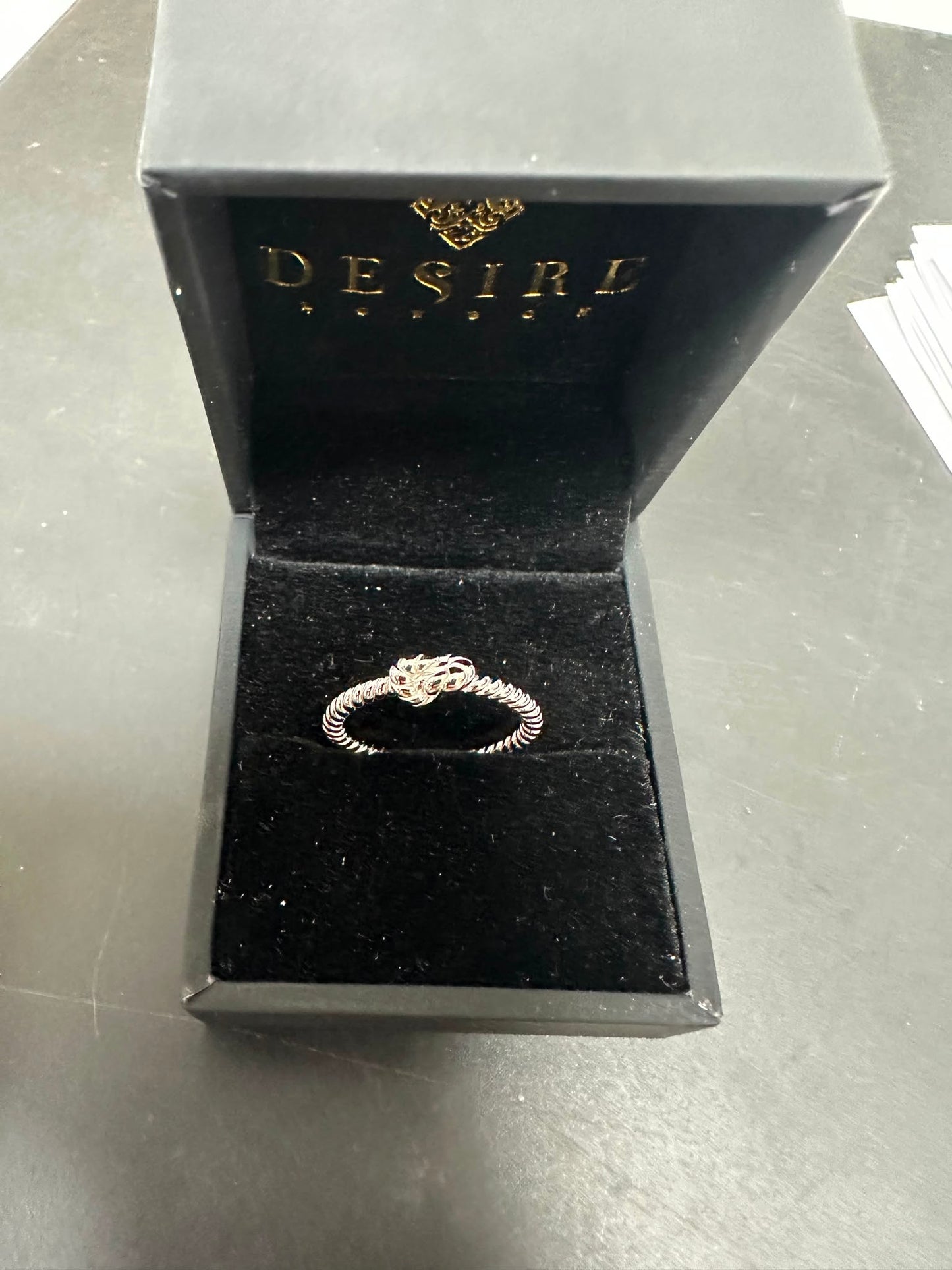 Sterling silver twisted ring displayed in an elegant Desire jewelry box, showcasing its unique design.