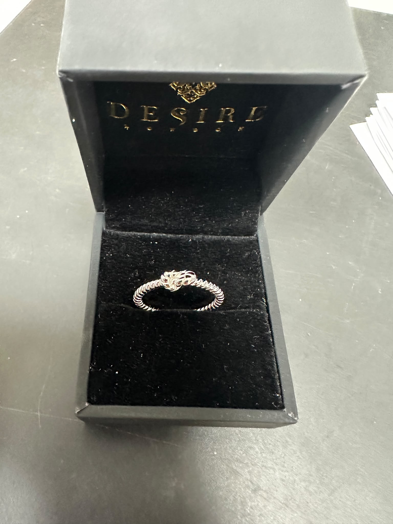 Sterling silver twisted ring displayed in an elegant Desire jewelry box, showcasing its unique design.